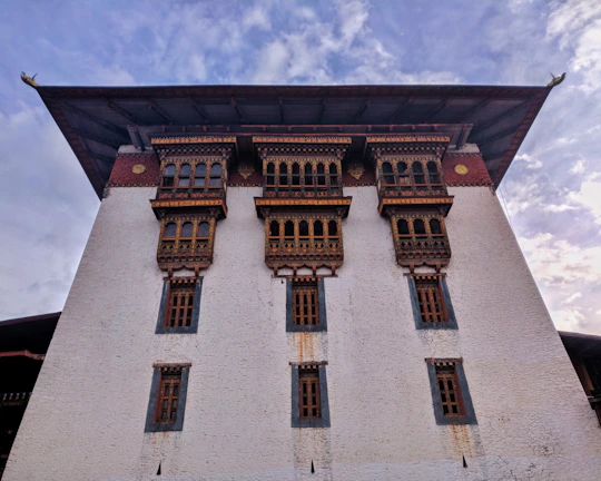 Traditional Nepali architecture framed by blooming rhododendrons and clear blue skies.