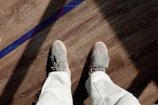 Comfortable dark grey men's jogger pants styled with white sneakers on a concrete floor.