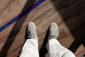 Comfortable dark grey men's jogger pants styled with white sneakers on a concrete floor.