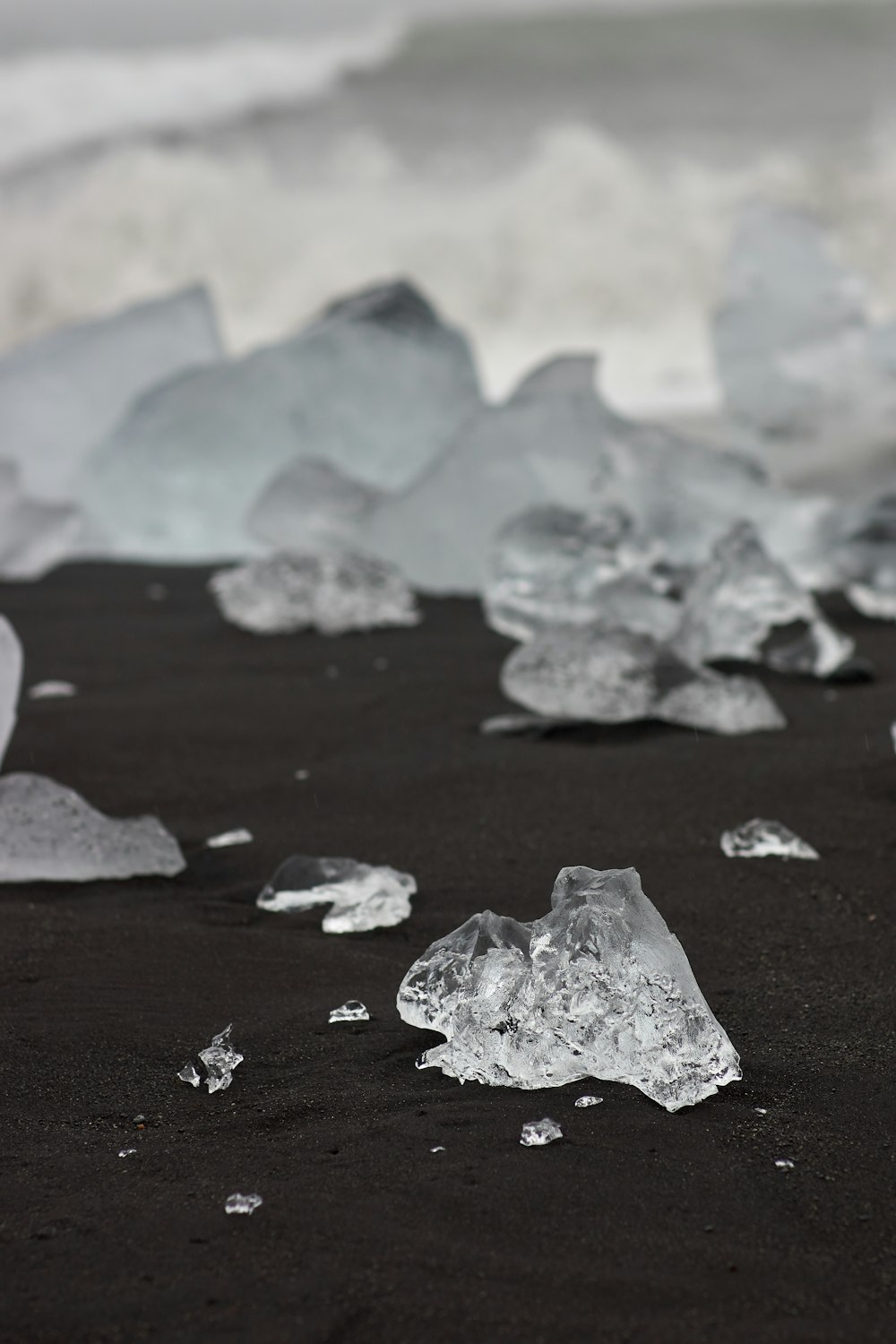 a black sand beach covered in lots of ice