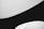 Curved black and white surfaces create a minimalist and abstract composition with clean lines and smooth contrasts.
