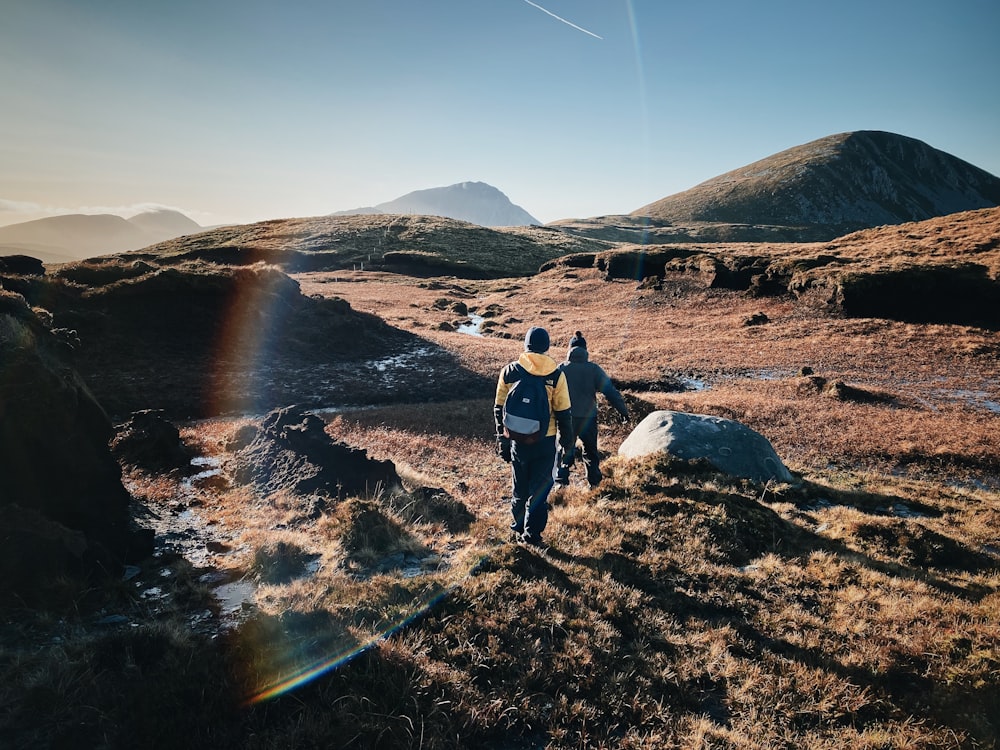 man and woman hiking on field