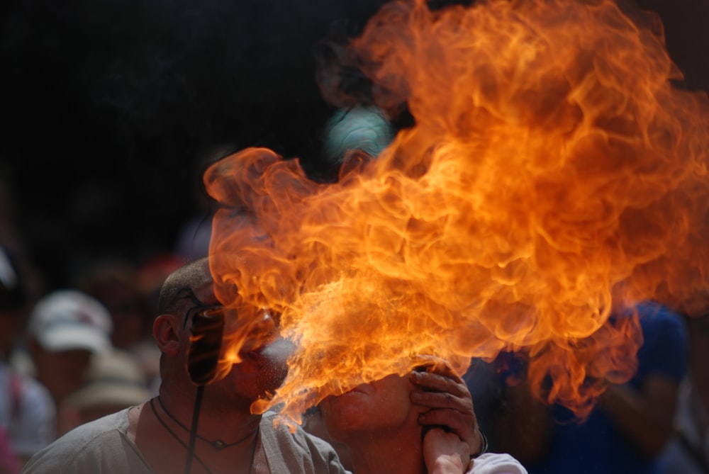 a man holding a burning object up to his face