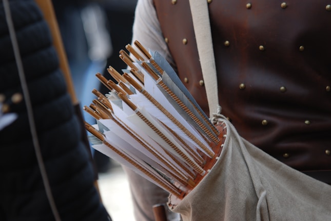 A handcrafted leather quiver filled with arrows, set against a forest backdrop.