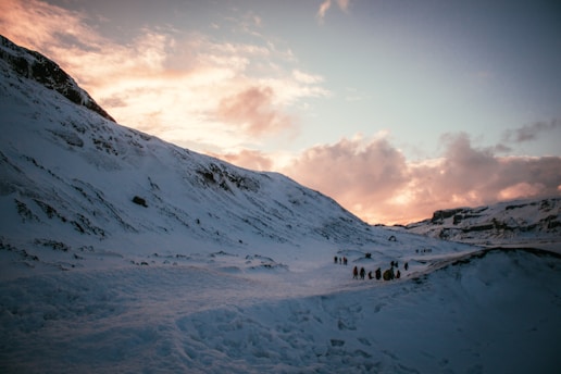 A group of travelers exploring a scenic mountain landscape during sunset.