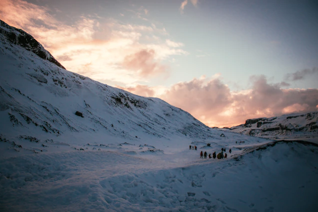 A vibrant photo of a group of happy travelers exploring a breathtaking mountain landscape at sunset.
