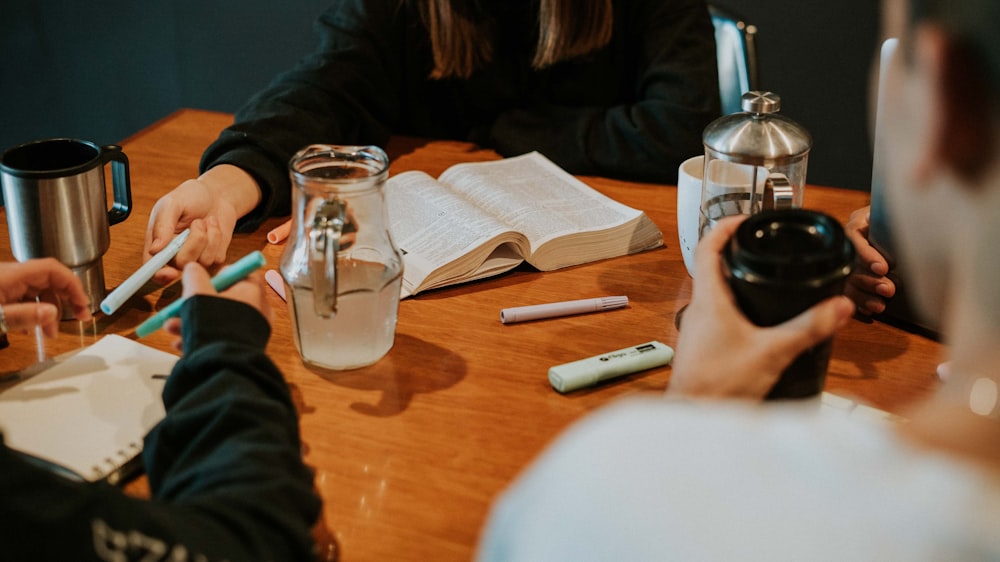 a group of people sitting around a wooden table