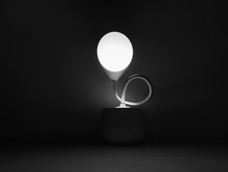 A contemporary table lamp with an artistic metal spiral design, glowing warmly.