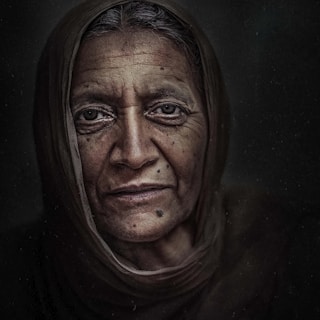 A stunning black and white portrait of an elderly woman with deep wrinkles and expressive eyes.