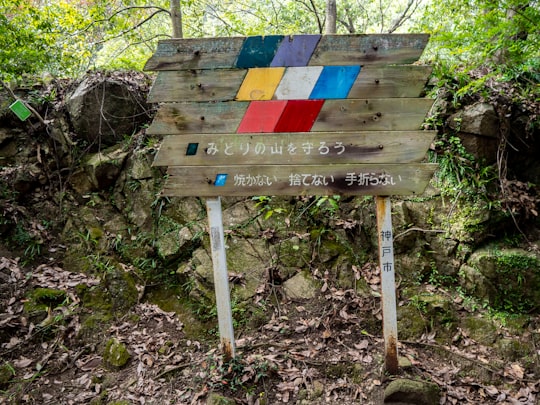 kanji script signboard on soil near rocks in Kobe Japan