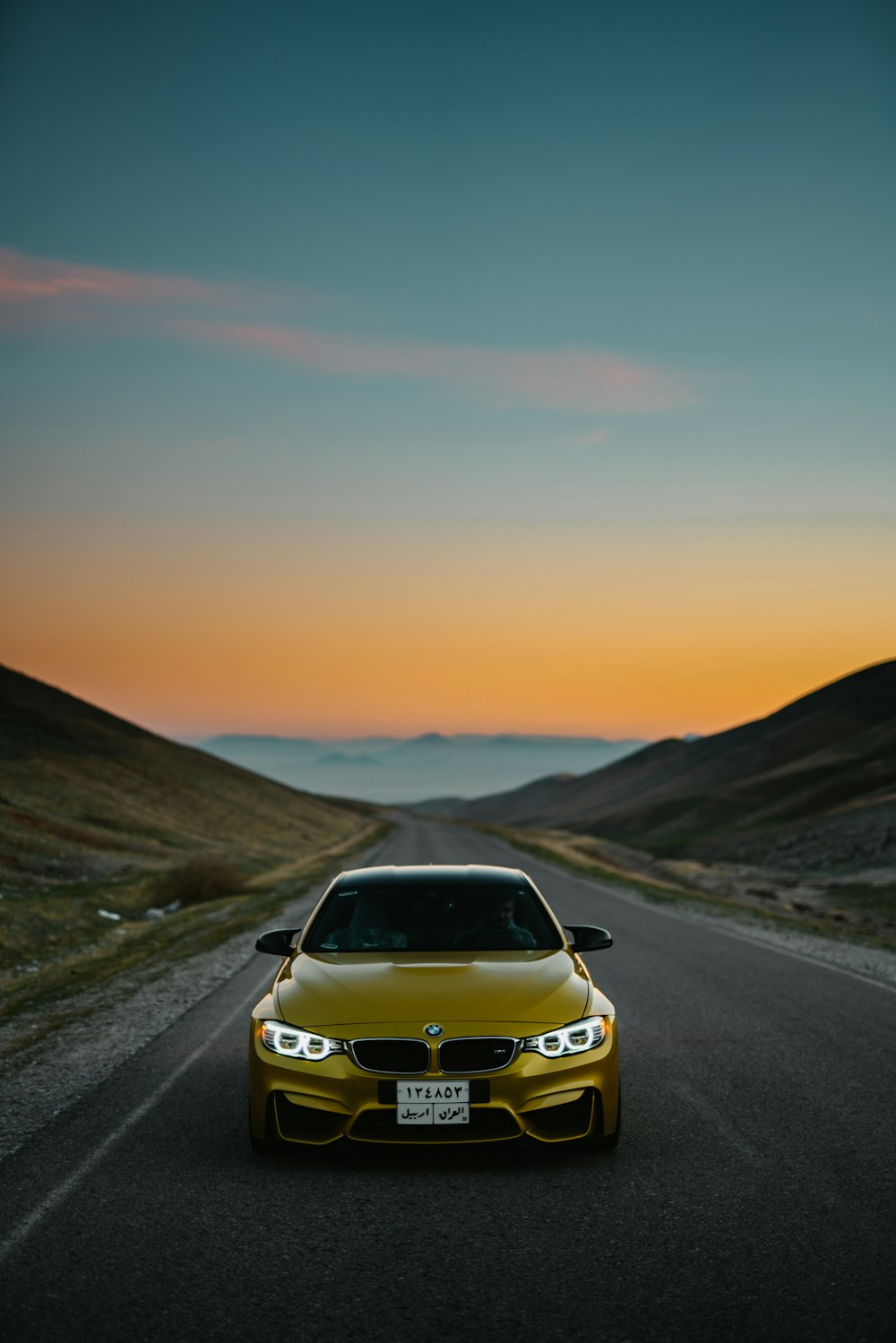 Coche BMW amarillo en carretera