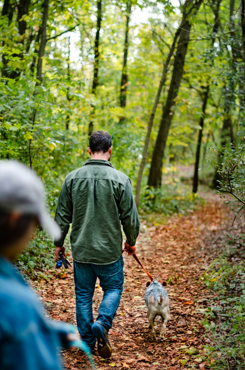 a man walking a dog in the woods