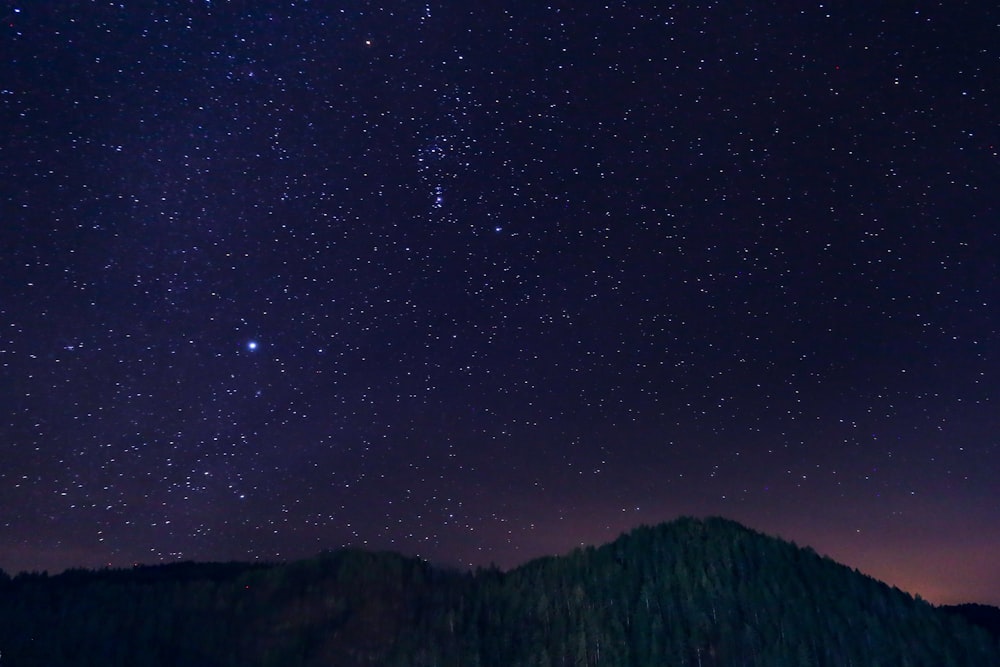 silhouette of mountains under starry night