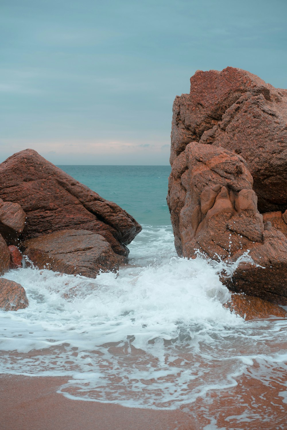 brown rock formation near body of water