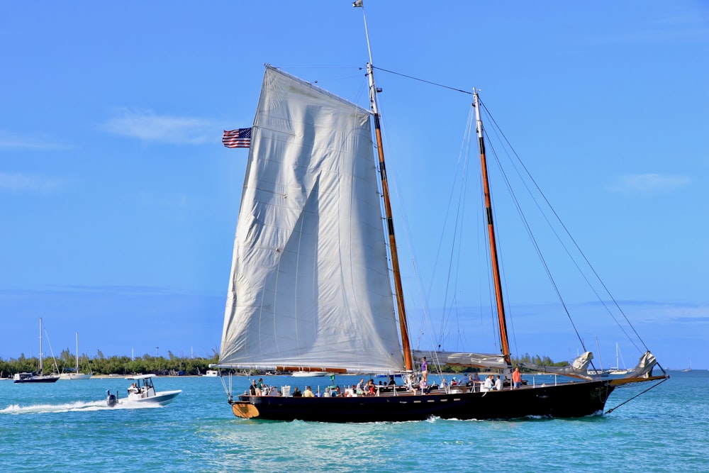 a sailboat with people on it in the ocean