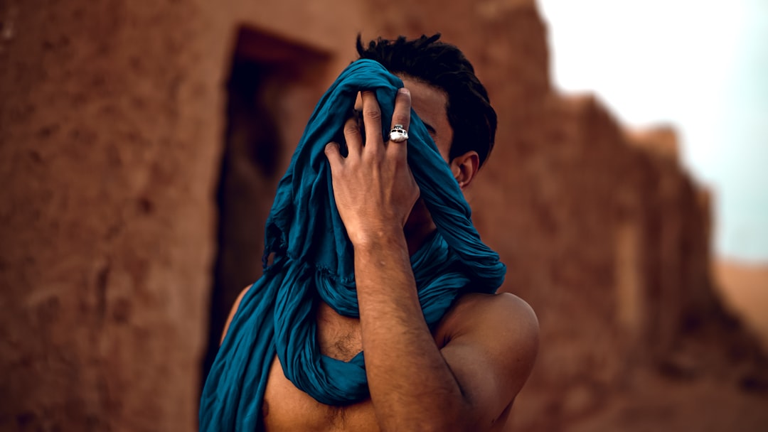 selective focus photography of man wearing blue scarf during daytime