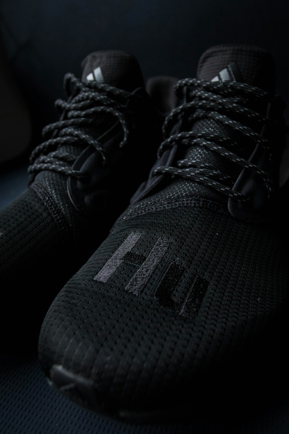 pair of black adidas Hu shoes
