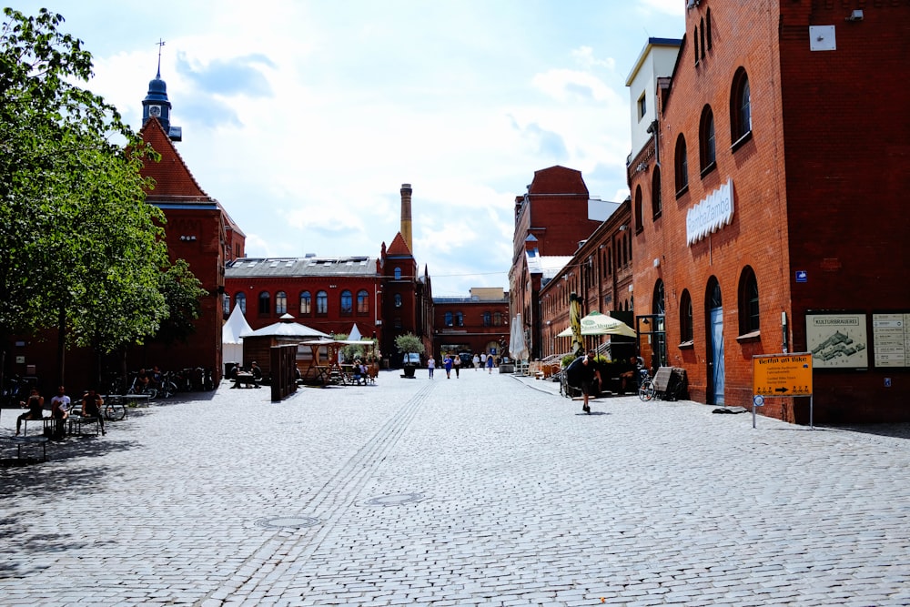 a cobblestone street lined with red brick buildings