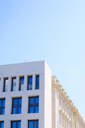 Renovated historic building with modern glass additions under a clear blue sky.
