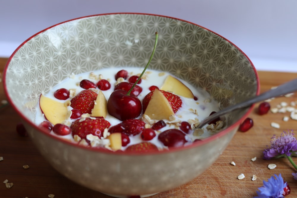 a bowl filled with yogurt and fruit on top of a table