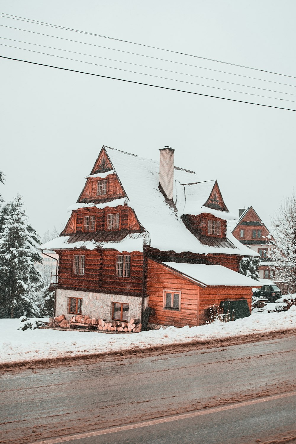 snow covered brown house beside road