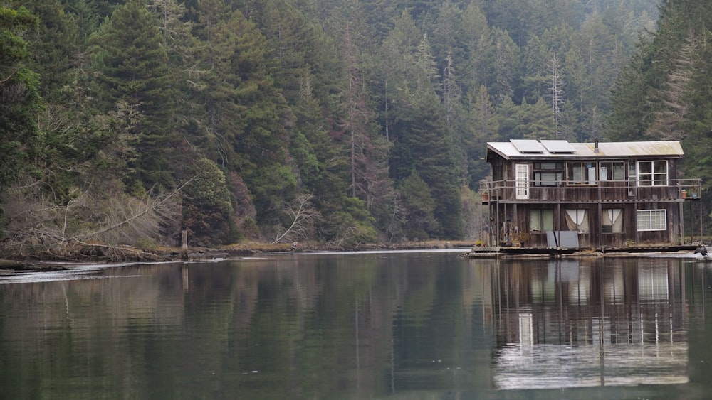 reflection of brown house on body of water surrounded by trees during daytime