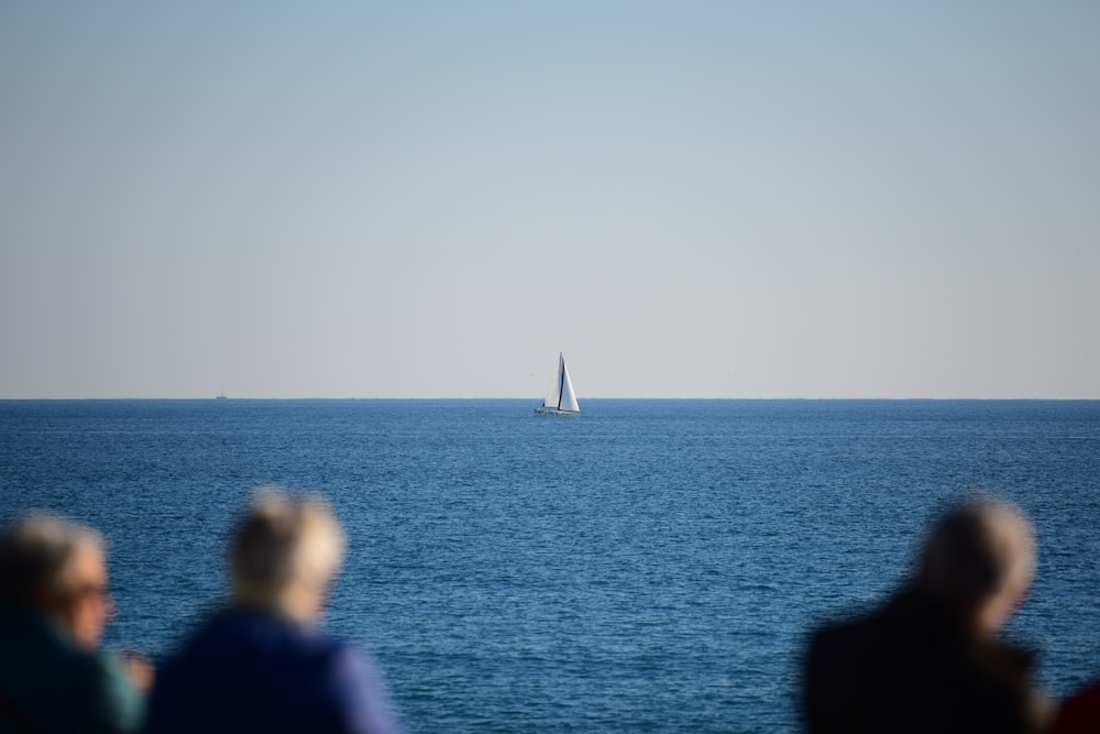people watching sailing boat during daytime