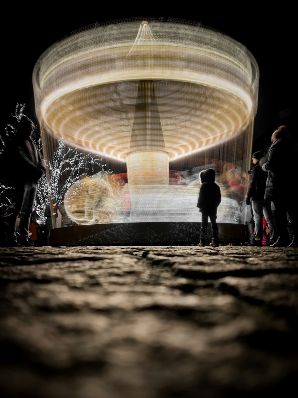 silhouette of people standing in front of water fountain at night