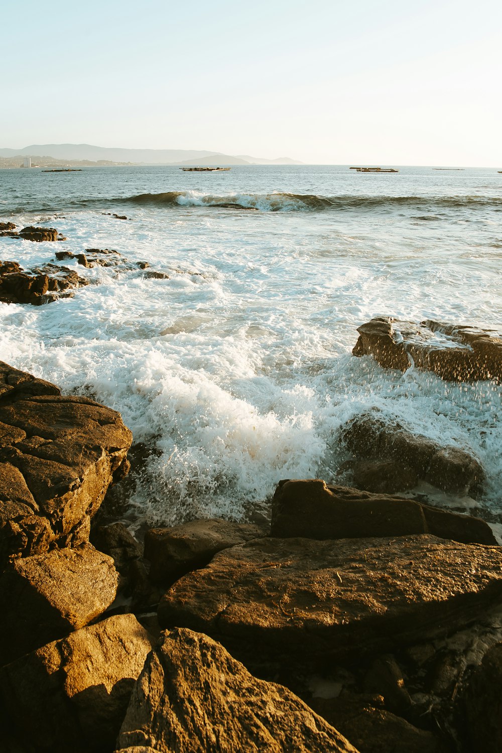 waves crashing on coastal rocks during daytime