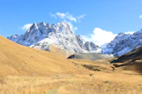 Snow-capped mountains under a clear blue sky with hikers enjoying the view