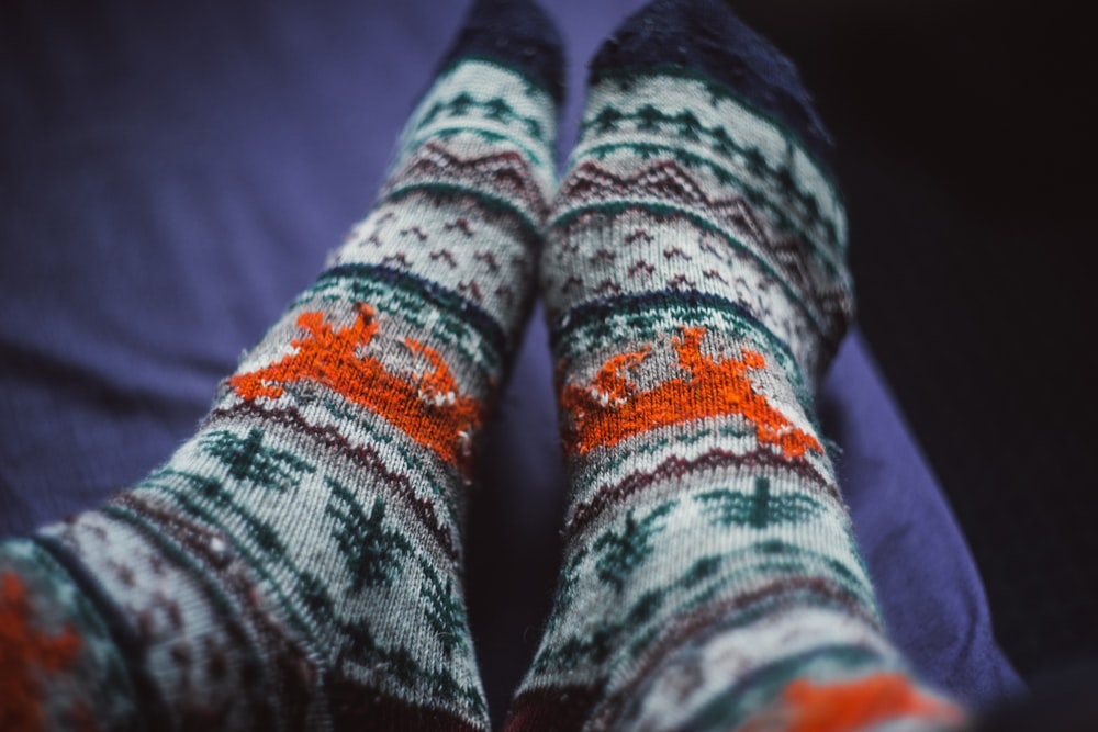 macro photography of person wearing multicolored printed socks
