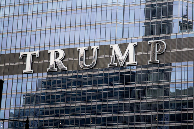 A polished metal ACM facade with glowing channel letters on a prominent commercial building.