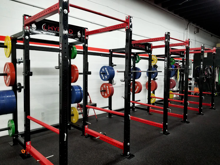 Row of red squat racks in a commercial gym
