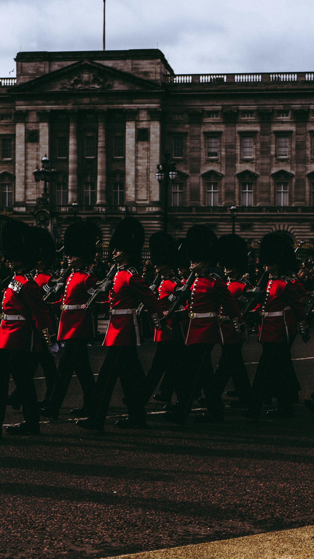 men marching near brown concrete building