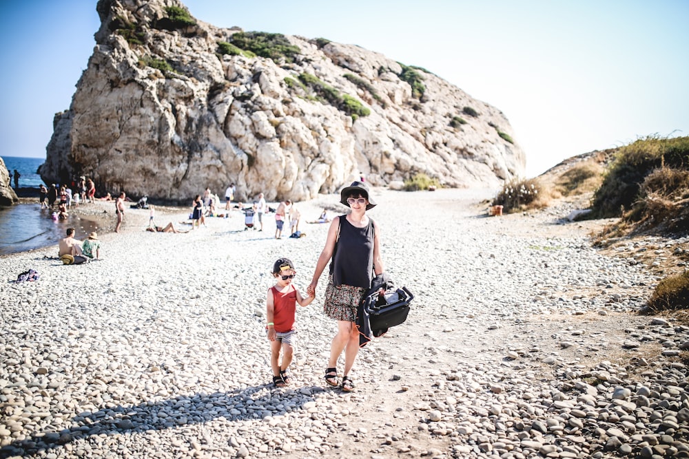 woman and child walking on the shore