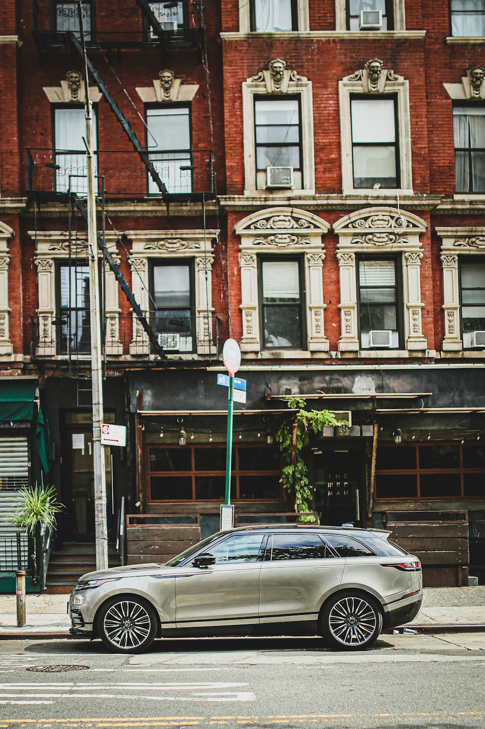 silver SUV parked near the red brick building