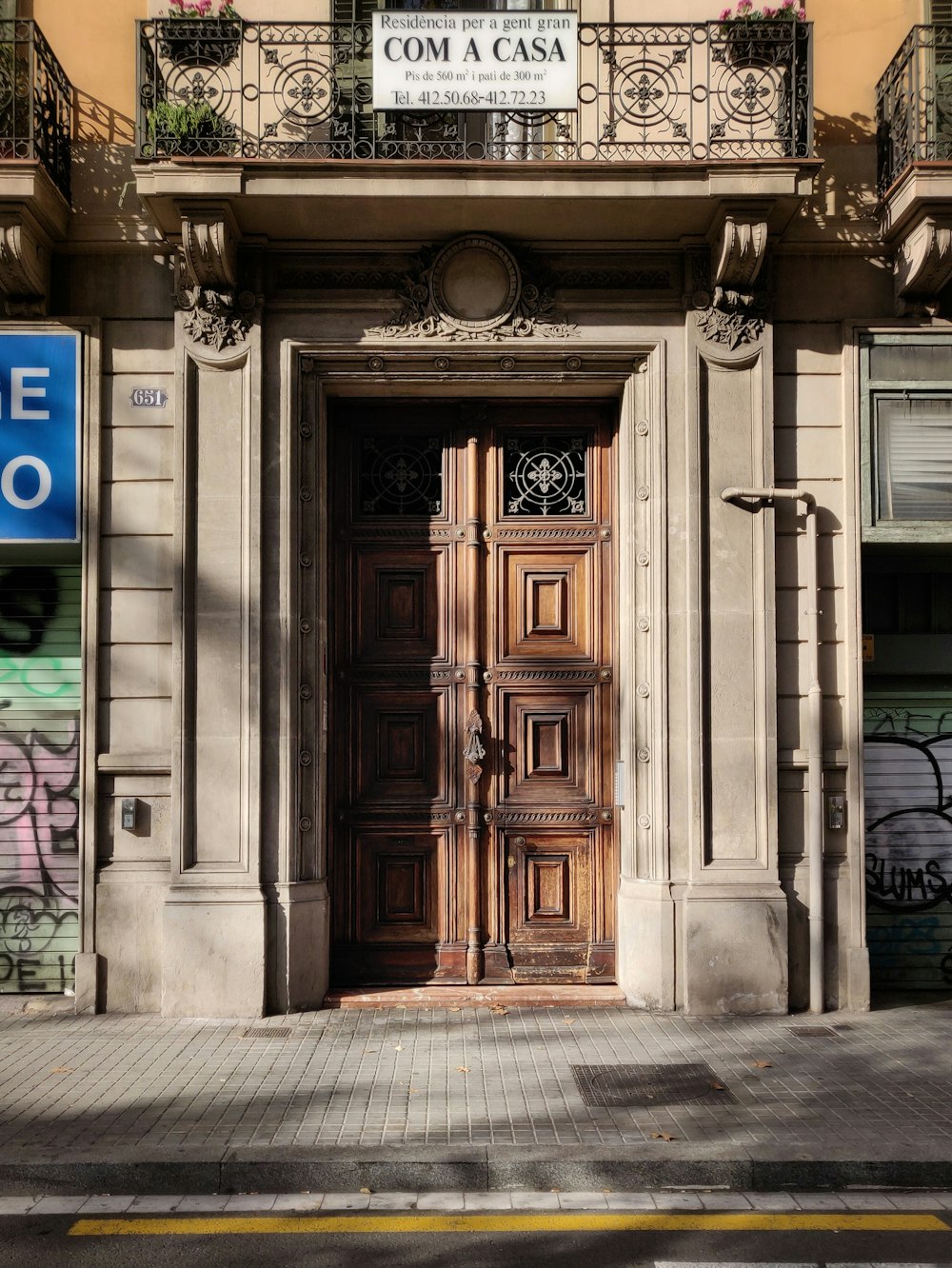 white concrete building showing closed brown wooden door