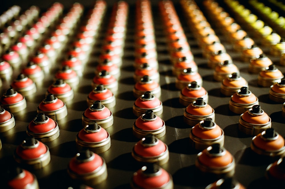 macro photography of red and orange spray cans