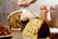 Joyful family unwrapping a panettone together in a cozy holiday setting.