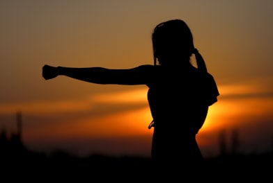 woman punching the air during golden hour