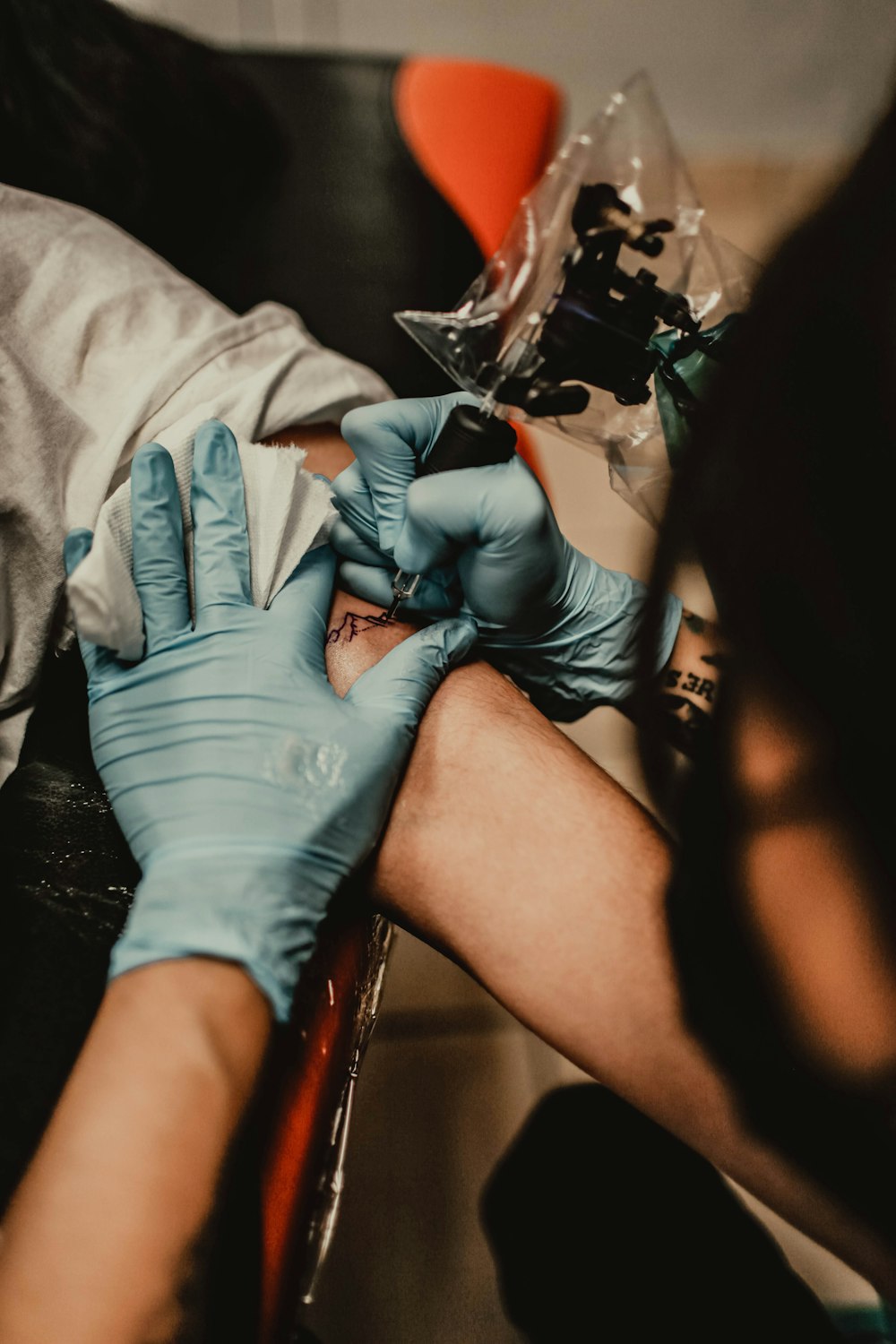 person tattooing person's arm