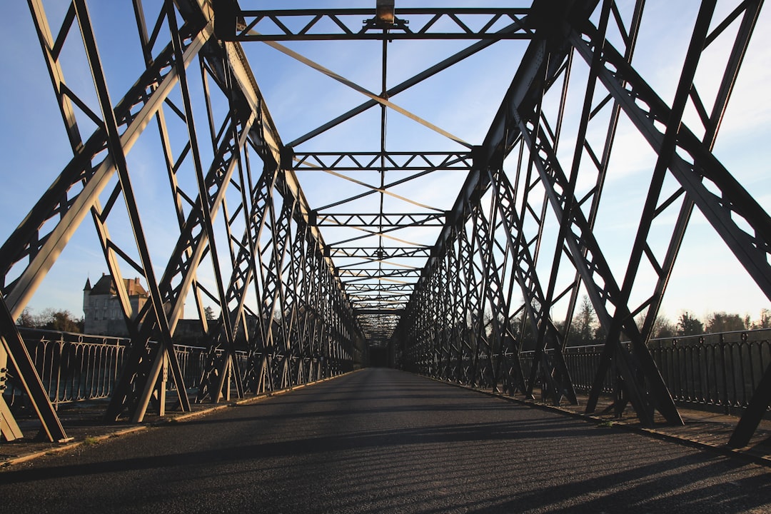 brown steel bridge under white and blue sky