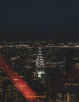 Night view of New York City skyline highlighting Nasdaq headquarters.
