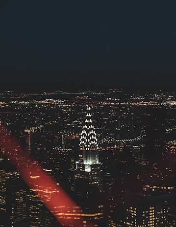 An artistic shot of iconic New York City skyline with fashion show lights in the foreground.