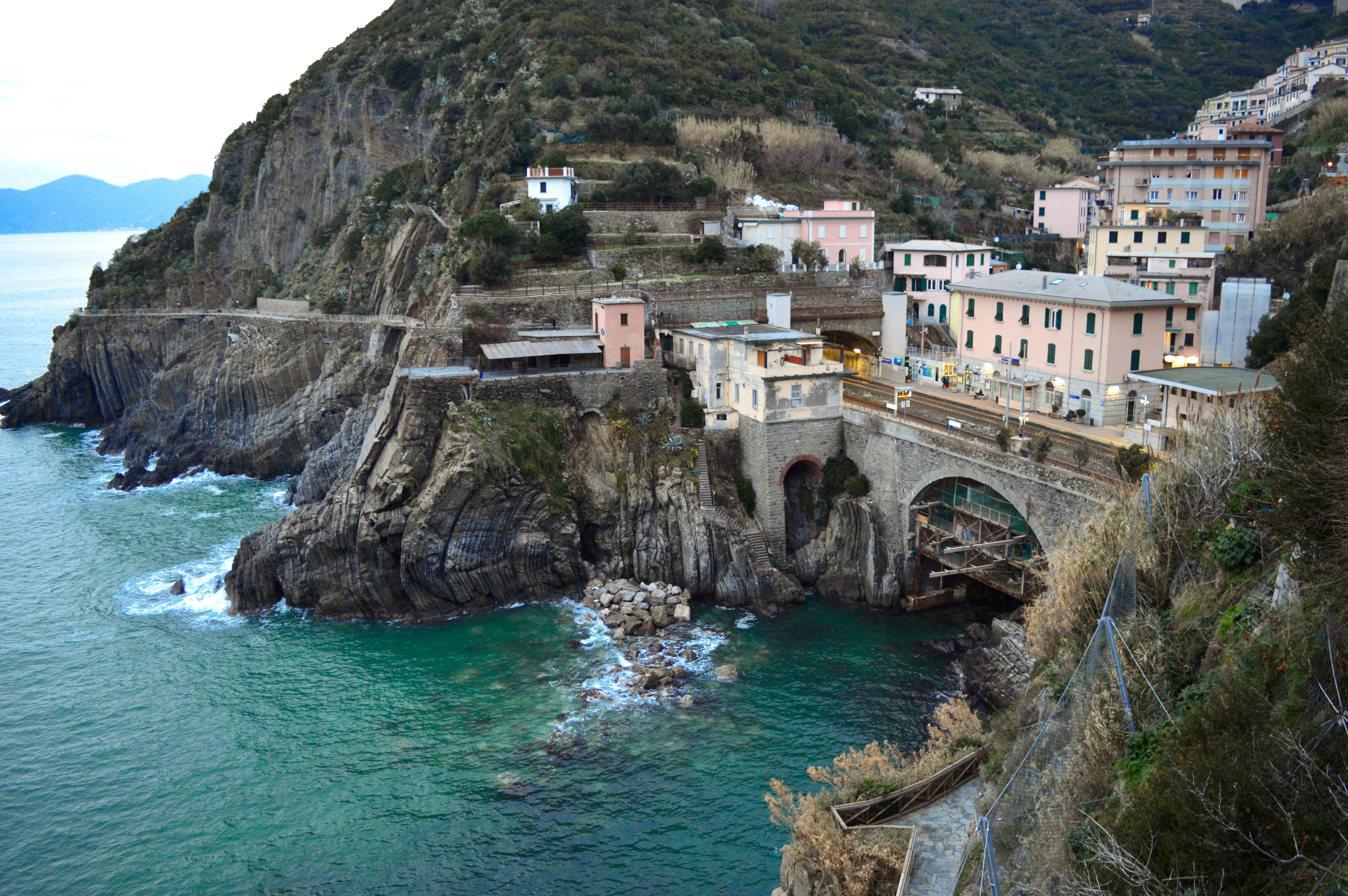 Fotografie von braunen und grauen Gebäuden in der Nähe von Bergen während des Tages
