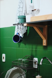 Close-up of a sleek kitchen holder mounted on a tiled wall.