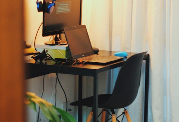 black wooden office table with laptop and monitor