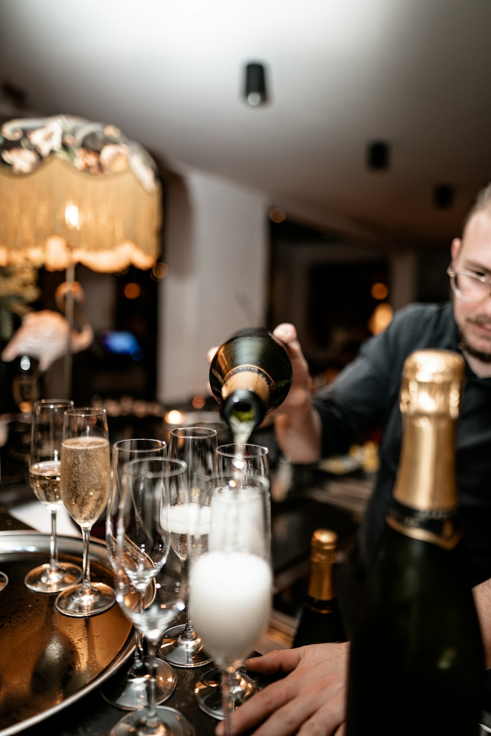 man pouring wine on clear flute glass