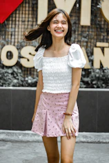 woman in white crop-top and pink skirt