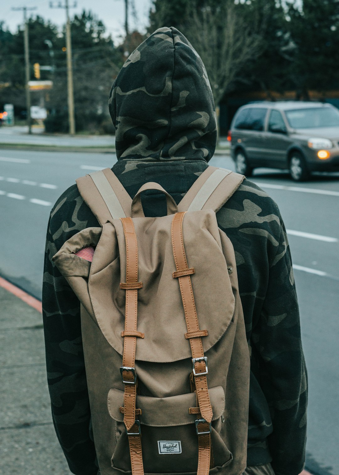 person wearing gray knapsack bag and hoodie jacket during daytime
